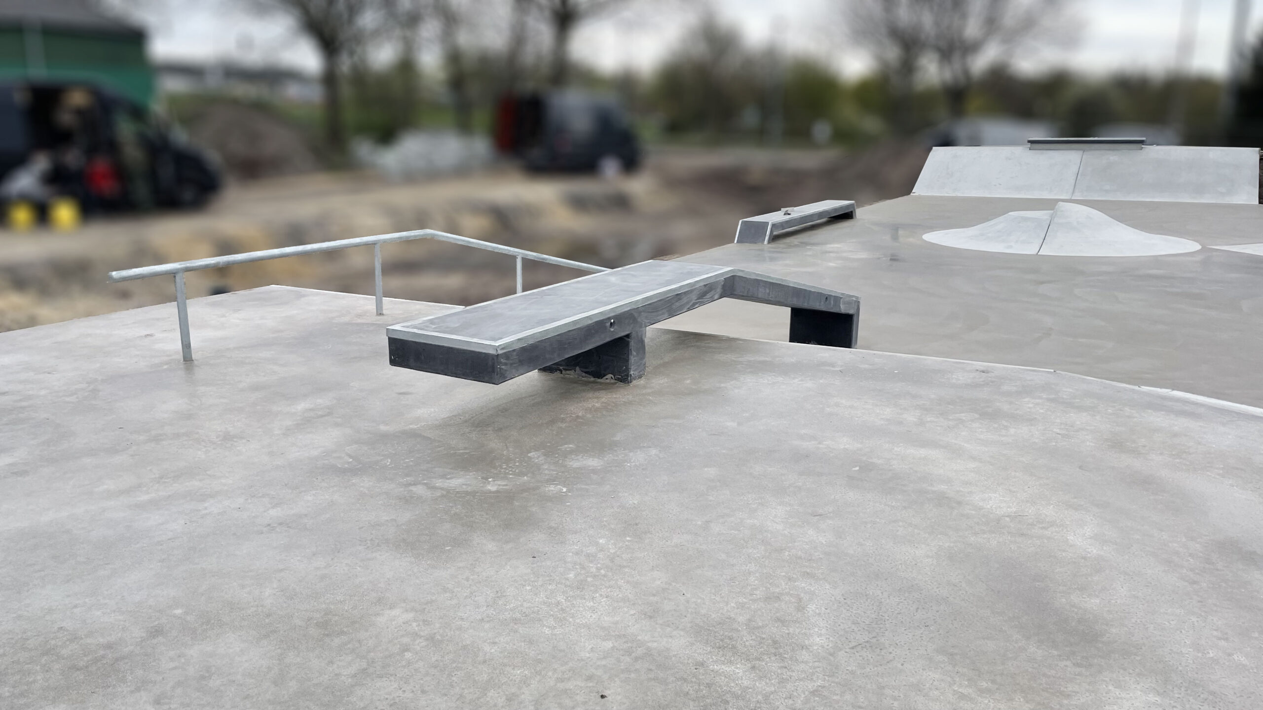 Ein schlichtes Bild eines Skateparks. Es sind Rampen und Rails zu erkennen.